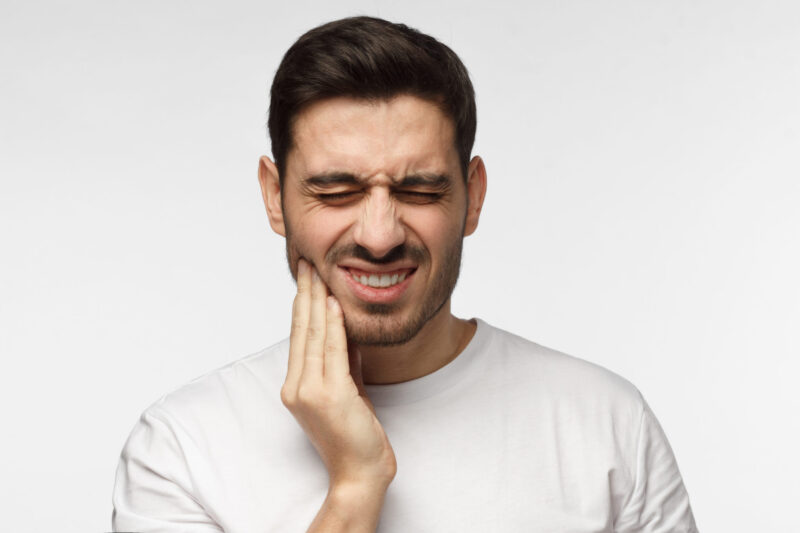 A man suffering from TMJ jaw pain.