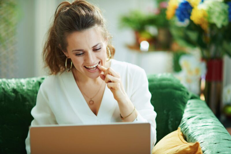 Woman pointing to her tooth during an online dentist appointment