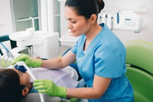 Dental professional administering nitrous oxide sedation to a young patient in a dental office.