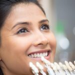 Smiling woman getting Lumineers color-matched to her natural teeth.