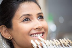 Smiling woman getting Lumineers color-matched to her natural teeth.